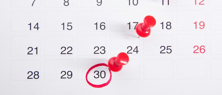 Calendário com alfinetes vermelhos marcando datas e o dia 30 circulado.